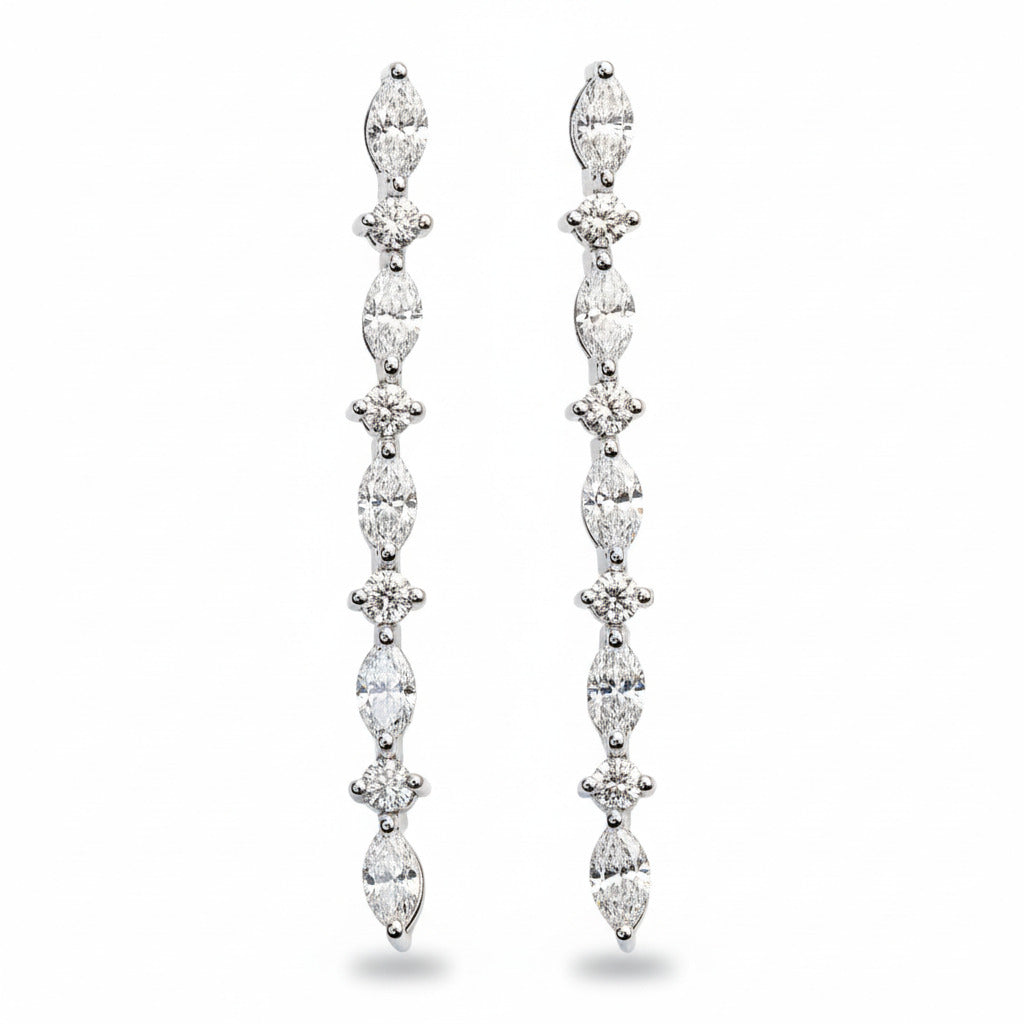 A pair of white gold drop earrings featuring marquise and round diamond shapes.